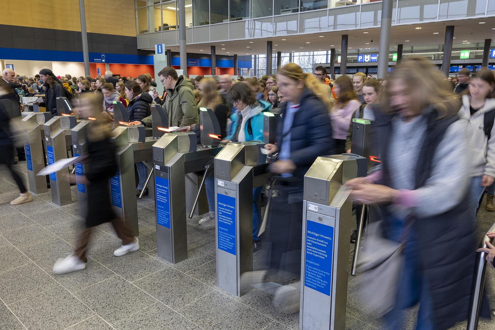Menschen ströhmen durch die Drehkreuze in der Eingangshalle der Passion Pferd